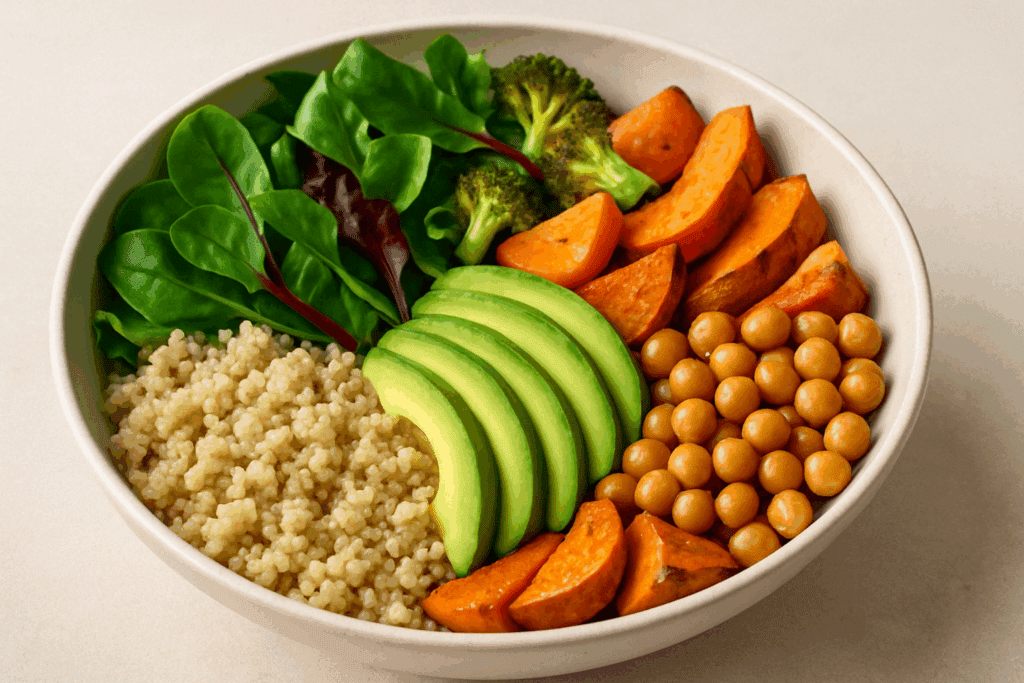 Colorful grain bowl with quinoa, avocado, chickpeas, leafy greens, and roasted vegetables representing a balanced whole foods diet.