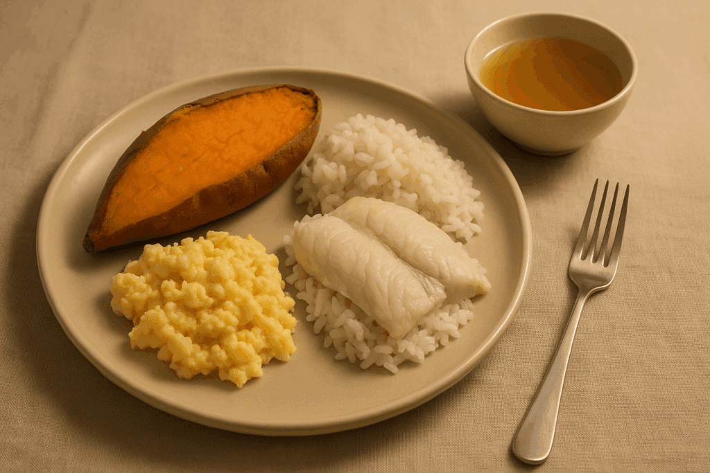 Balanced dinner plate with baked sweet potato, scrambled eggs, white fish over rice, and broth—perfect example of easy-to-digest foods.